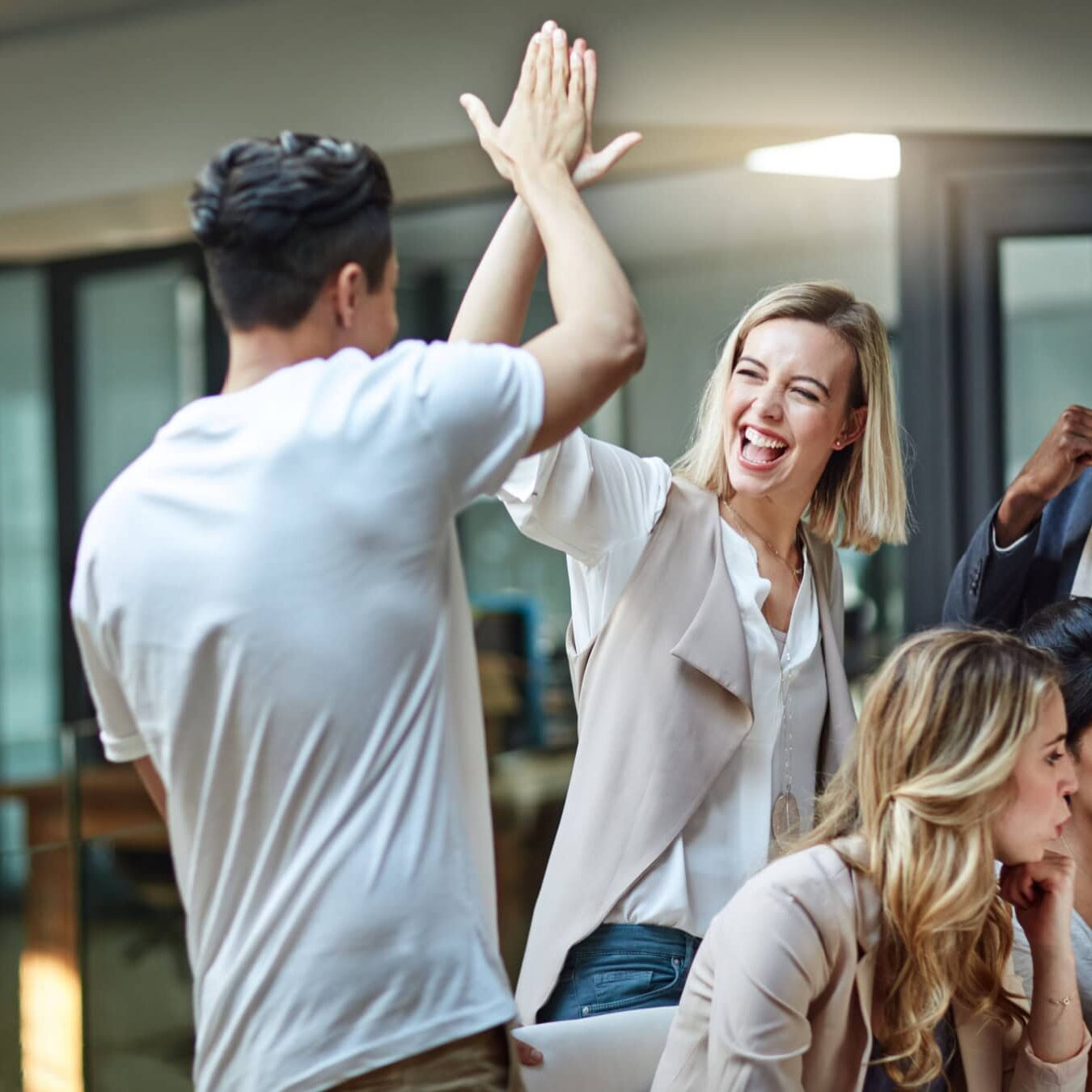 Two people high five in celebration of the Coach Educators networking
