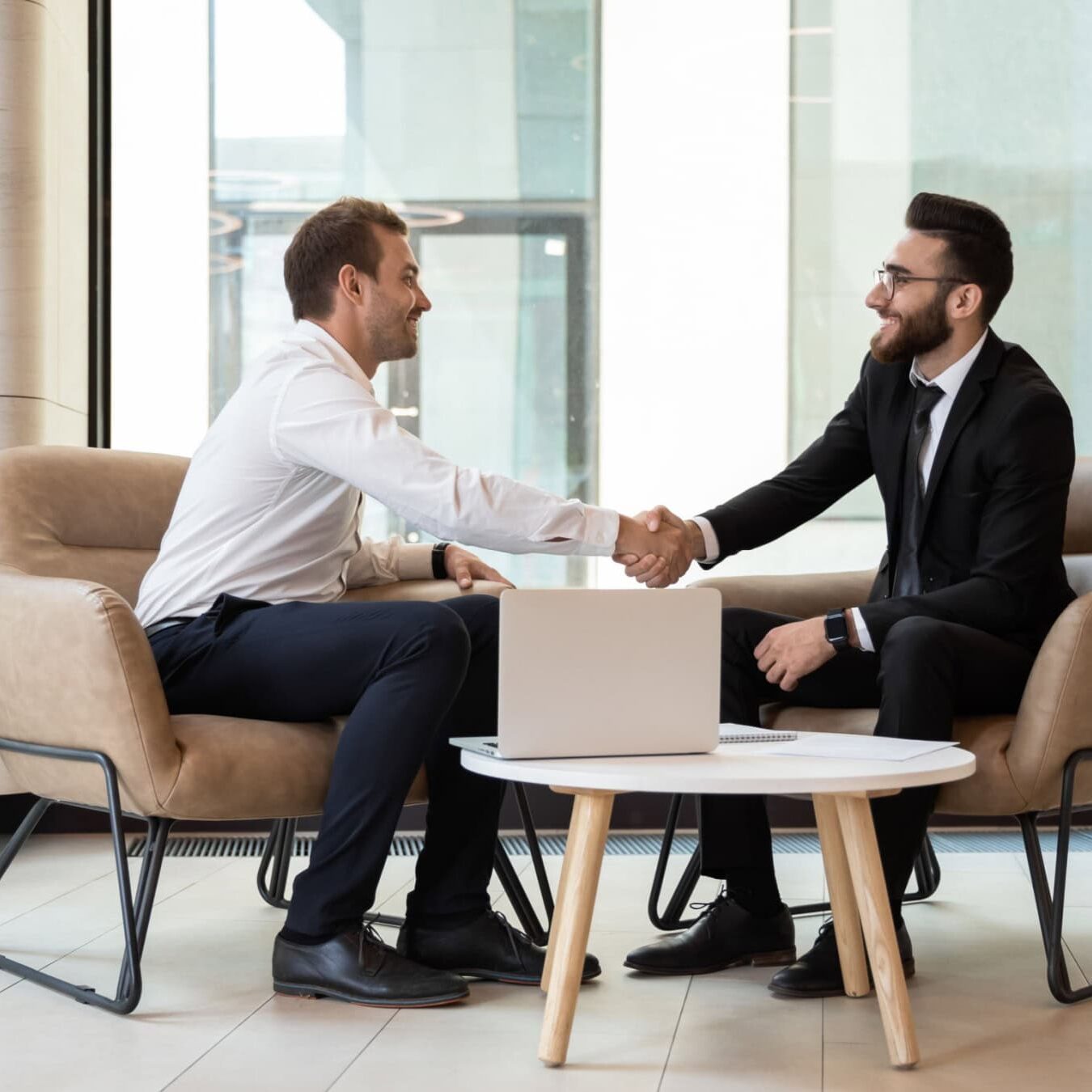 Two men shake hands in an office setting after discussing who should apply for CCE Accreditation