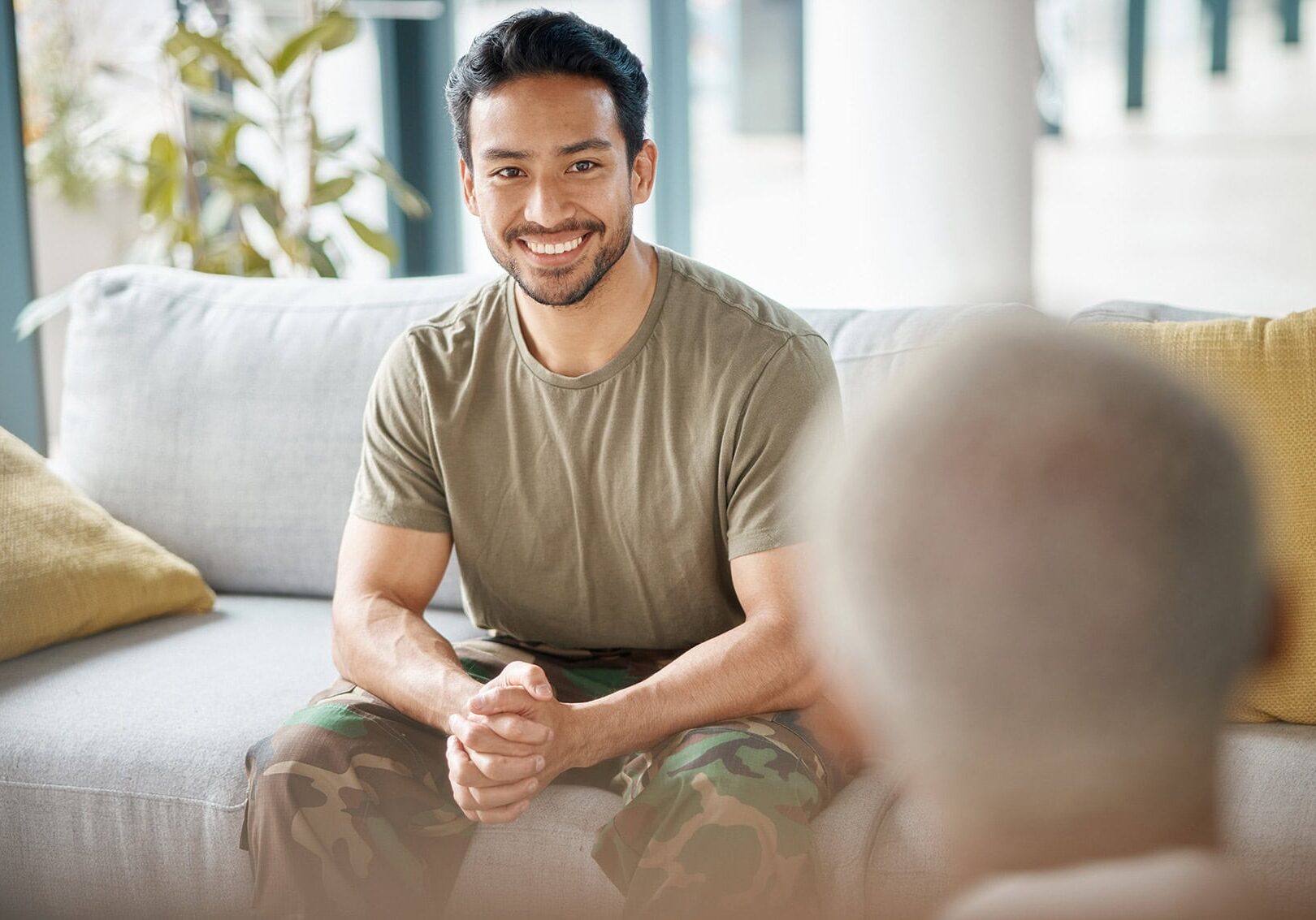 Army veteran and counselling with therapist for mental health, help or support on sofa in office