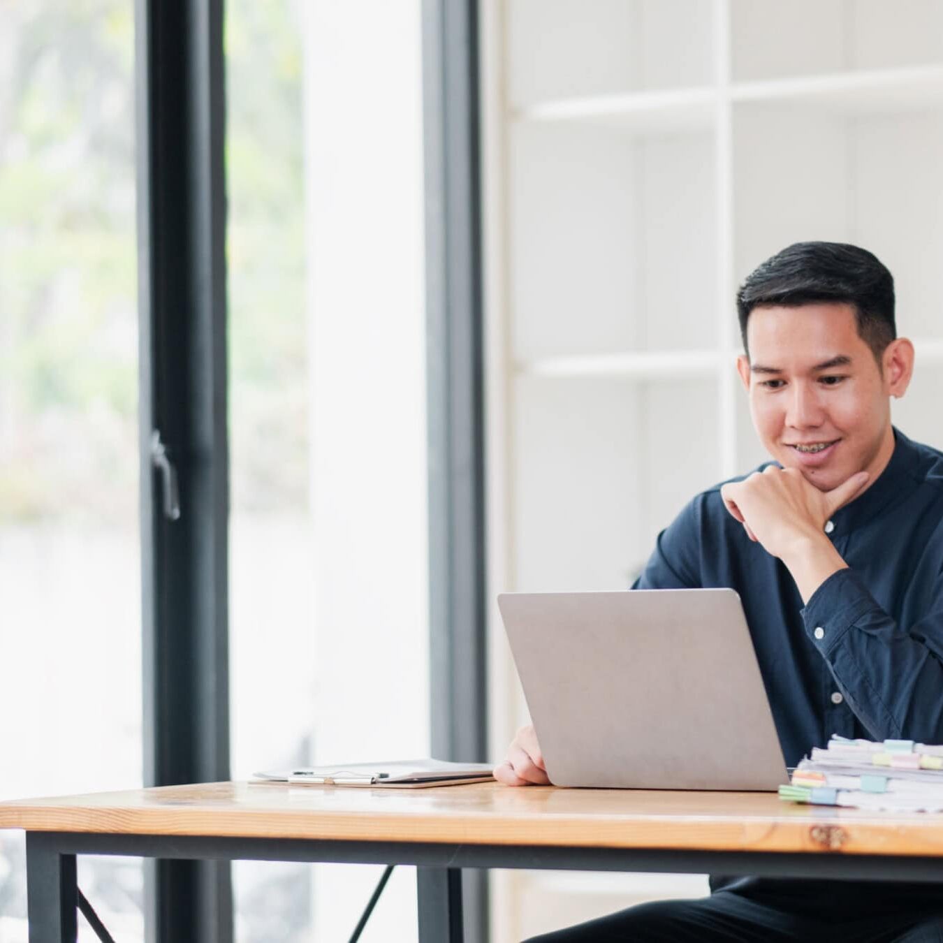 A man and women look at a computer screen to see requirements