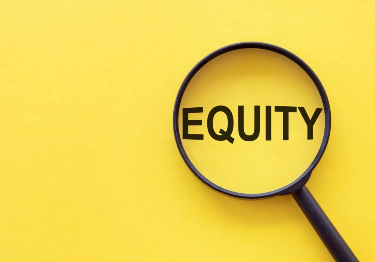 The word "Equity" under a magnifying glass on a bright yellow background, symbolizing close examination of fairness in credentialing.