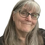 Headshot of Pamela Richarde, smiling woman with gray hair wearing glasses in front of white background