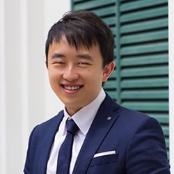 Jedidiah Koh ACTC MCC headshot photo, smiling man with dark hair in blue suit