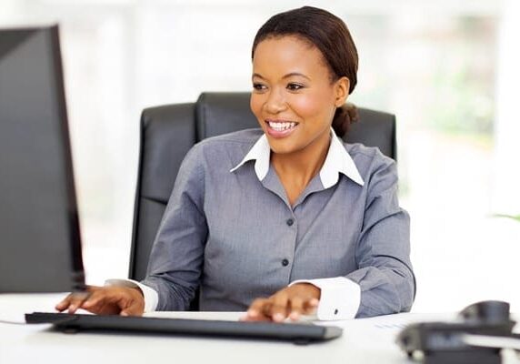 female coach sitting at a desk working on a computer