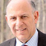Andre Politzer headshot photo, smiling man wearing suit outside
