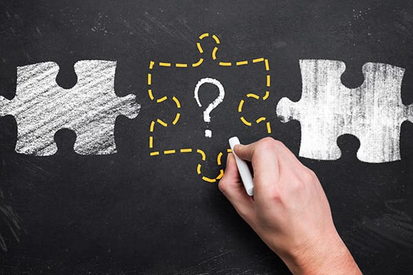 chalkboard drawings of puzzle pieces with the middle in a dotted yellow outline with a question mark in the middle